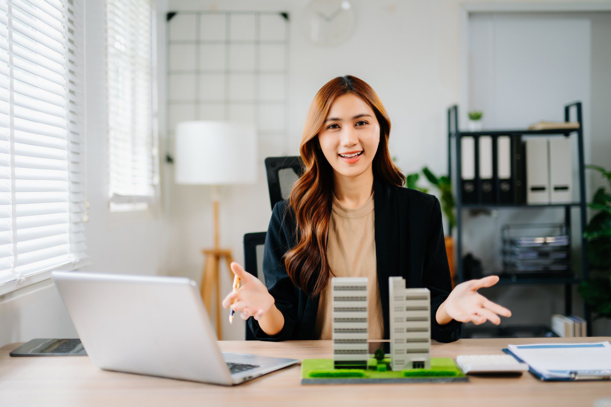 Woman presenting architectural models at desk