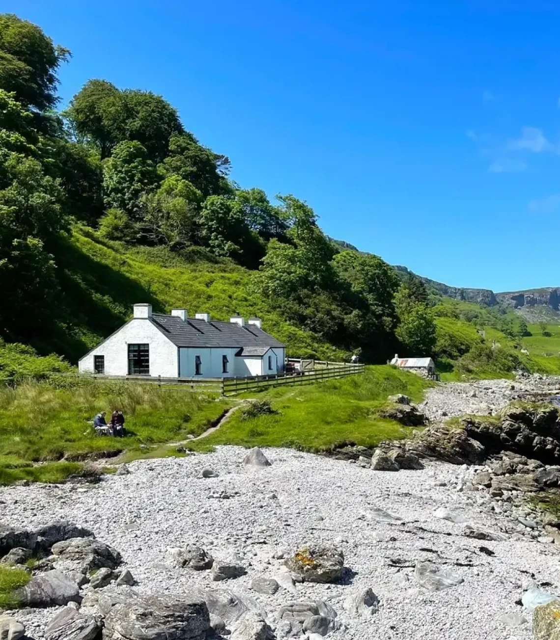 White cottage by rocky shoreline