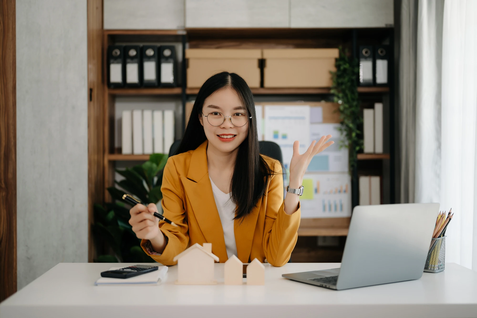 Businesswoman with laptop and house models.